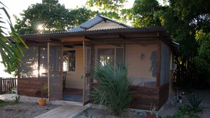 A small wooden cabin with a porch, a door, and windows.