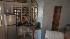 A compact kitchen with a refrigerator, sink, and wooden table.