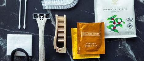 A variety of toiletries and a wooden muddler on a marble surface.