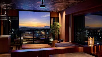 A modern interior with a large window overlooking a cityscape at dusk.