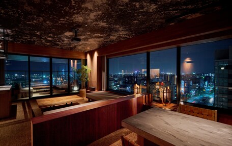A modern interior with a city view, a bar area, and a seating space.