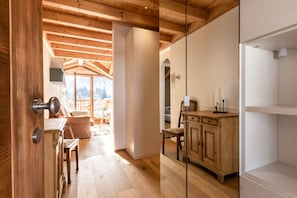 Un interior de madera con una cocina, una mesa de comedor y vistas al exterior.