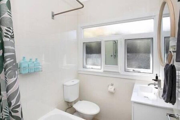 Un baño con inodoro, lavamanos y ventana.