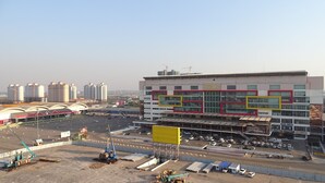 A commercial building with a large parking lot in front, surrounded by high-rise buildings. - VIENTIANMEKONGHOTEL (Vientiane)
