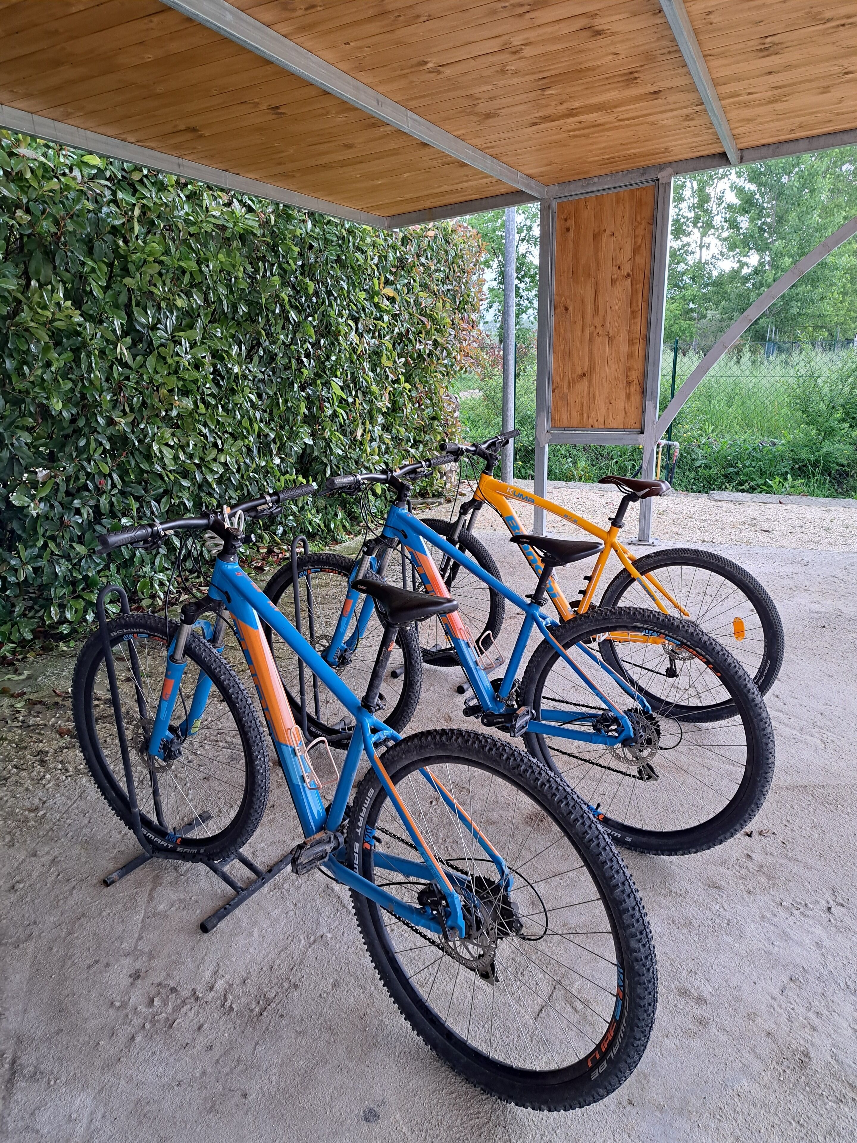 Uma área de estacionamento coberta para bicicletas, com três bicicletas.