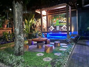 Un'area giardino con una struttura in legno, una fontana e un angolo relax.