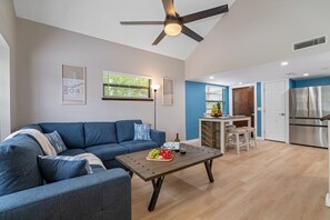 Relax in this spacious living area with a sofa, coffee table, and large window offering a view.