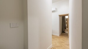 A hallway with a wooden floor, white walls, and a door leading to another room. - Firenze Duomo Suite apartment by Mmega (Firenze)