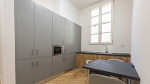 A compact kitchen with grey cabinets, a microwave, a sink, and a window. - Firenze Duomo Suite apartment by Mmega (Firenze)