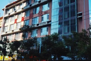 Un immeuble à plusieurs étages, dont la façade est ornée d ’une grande enseigne rouge bien visible.