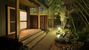 Una casa con terraza de madera y un sendero que lleva a la entrada.