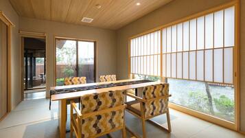 A traditional Japanese-style room with tatami flooring, a low wooden table, and shoji screens.