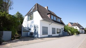 Une maison d’habitation à deux étages, dotée d’un toit en pente, de grandes fenêtres et d’un garage.