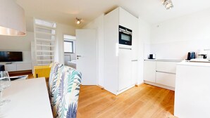 A compact living space with a kitchenette, a dining area, and a sofa.