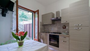 A kitchen with light wood cabinets, a gas stove, and a built-in oven.