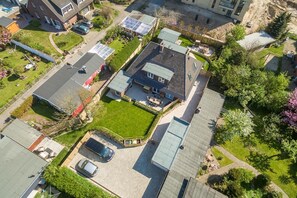 Vista aérea de una zona residencial con casas, céspedes verdes e instalaciónes solares.