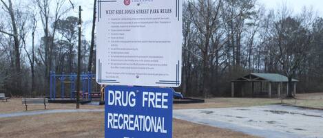 A park sign indicating West Side Jones Street Park Rules and a Drug Free Recreational Zone sign.