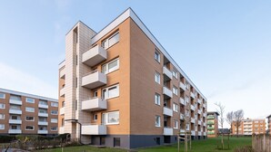 A multi-story residential building with balconies, a flat roof, and a brick facade. - Haus Südstrand Whg. 174 - Haus Südstrand, Gemütliche 2-zimmerwohnung auf ca. 38 m² für bis zu 4 (Sylt)