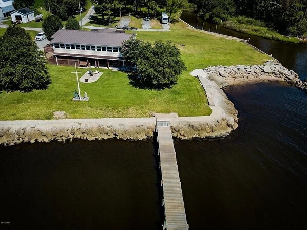 An aerial view of a lakeside property with a dock leading to a grassy area with a building and a playground. - 3 BR waterfront river home; spectacular views (Arapahoe)