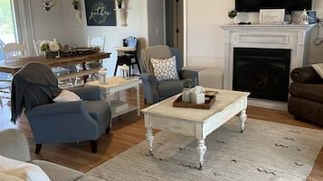 Télévision, cheminée, lecteur de DVD, livres