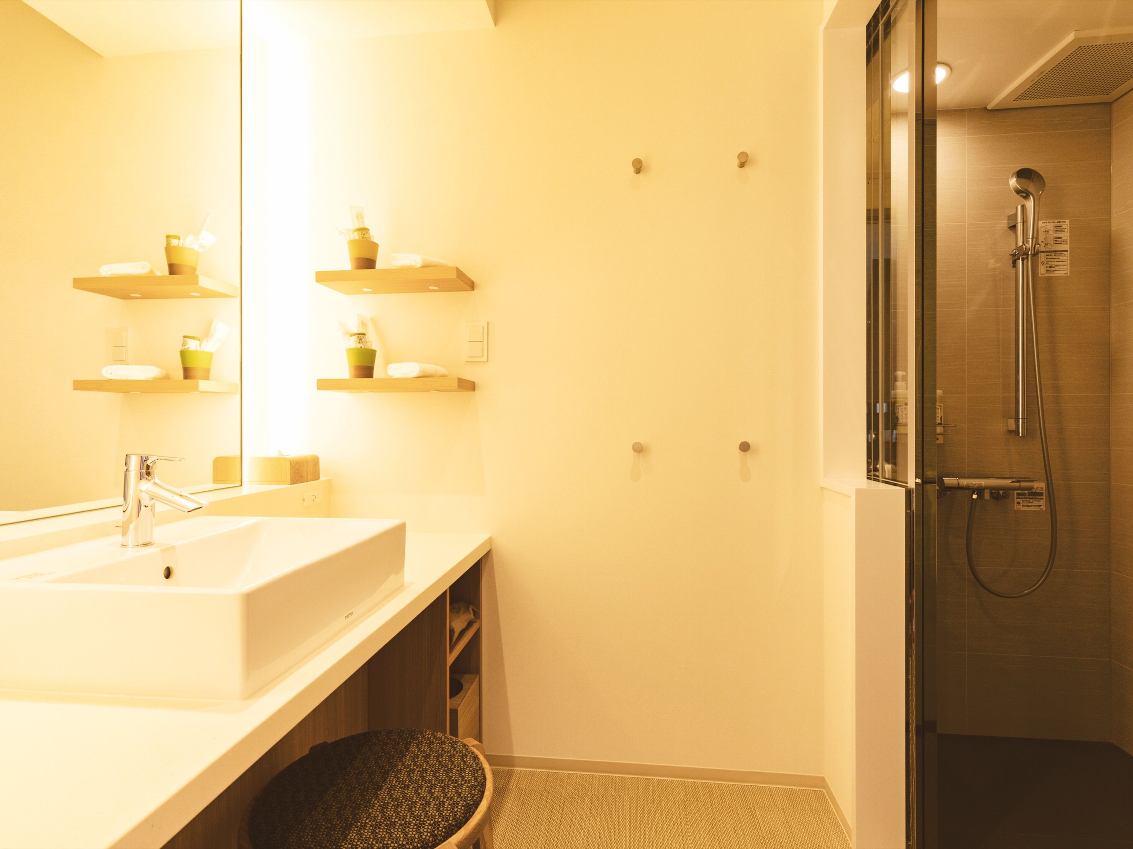 Un baño moderno con un lavamanos grande, un espejo y una ducha con cerramiento de vidrio.