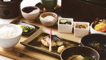 Una comida tradicional japonesa con diversos platos, incluyendo arroz, pescado y sopa.