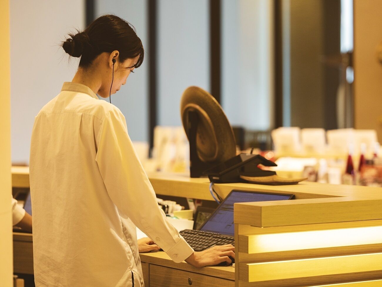 Iemand werkt aan een houten bureau met een computer, koptelefoon en headset.