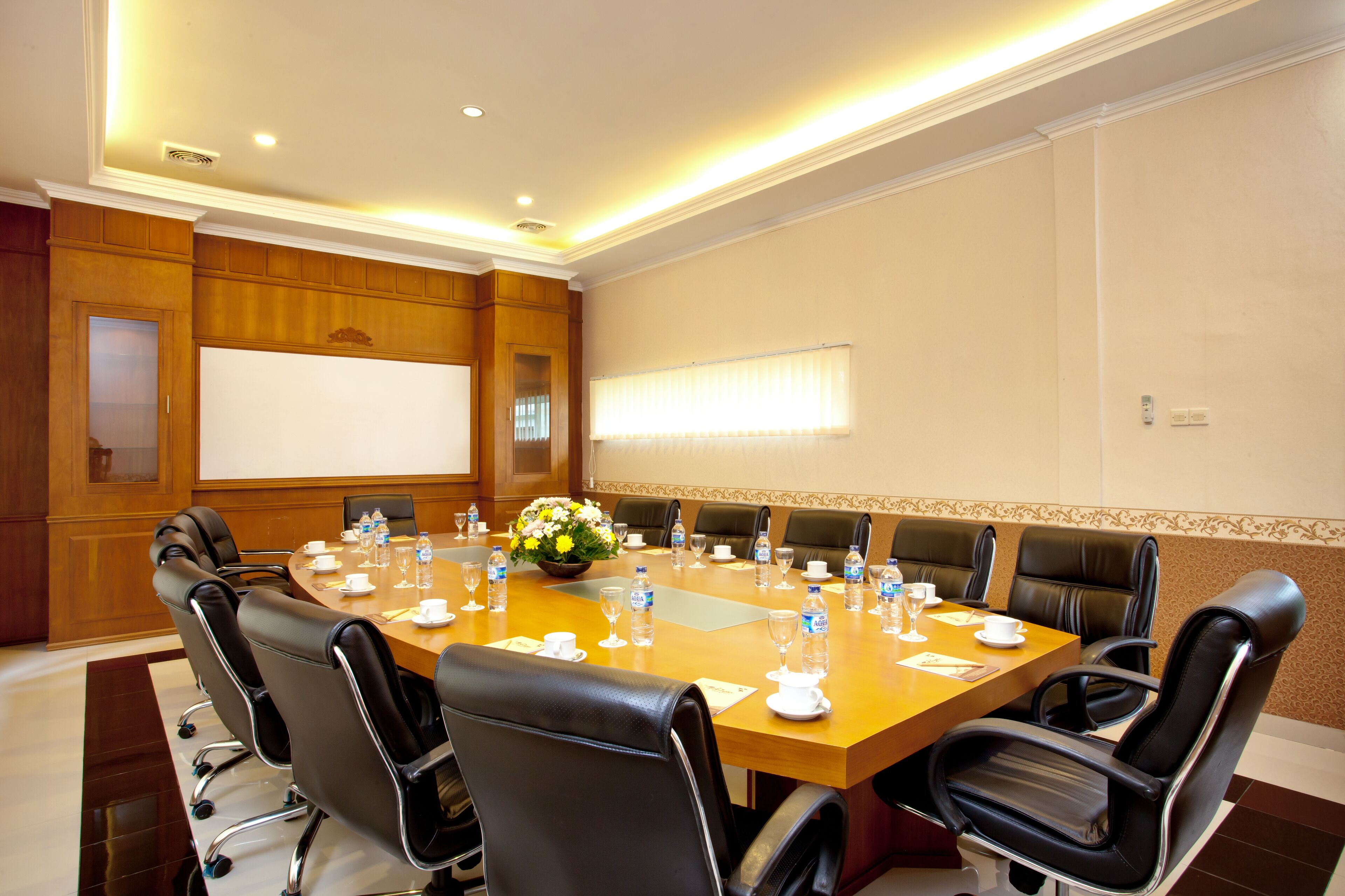 A conference room with a large table, chairs, and a whiteboard.