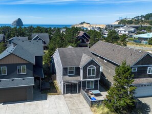 A residential area with houses, a clear sky, and a distant view of the ocean.