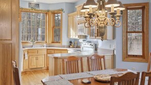 A kitchen with wooden cabinets, a central island, and a chandelier.