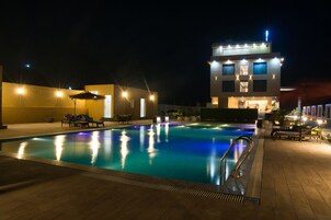 Una piscina al aire libre, sombrillas, tumbonas