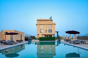 Una piscina al aire libre, sombrillas, tumbonas