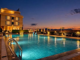 Una piscina al aire libre, sombrillas, sillones reclinables de piscina