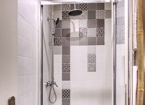 A shower with a glass door, featuring a variety of black and white tile patterns. - Palacete da Baixa, Studio Superior appartment (Faro)