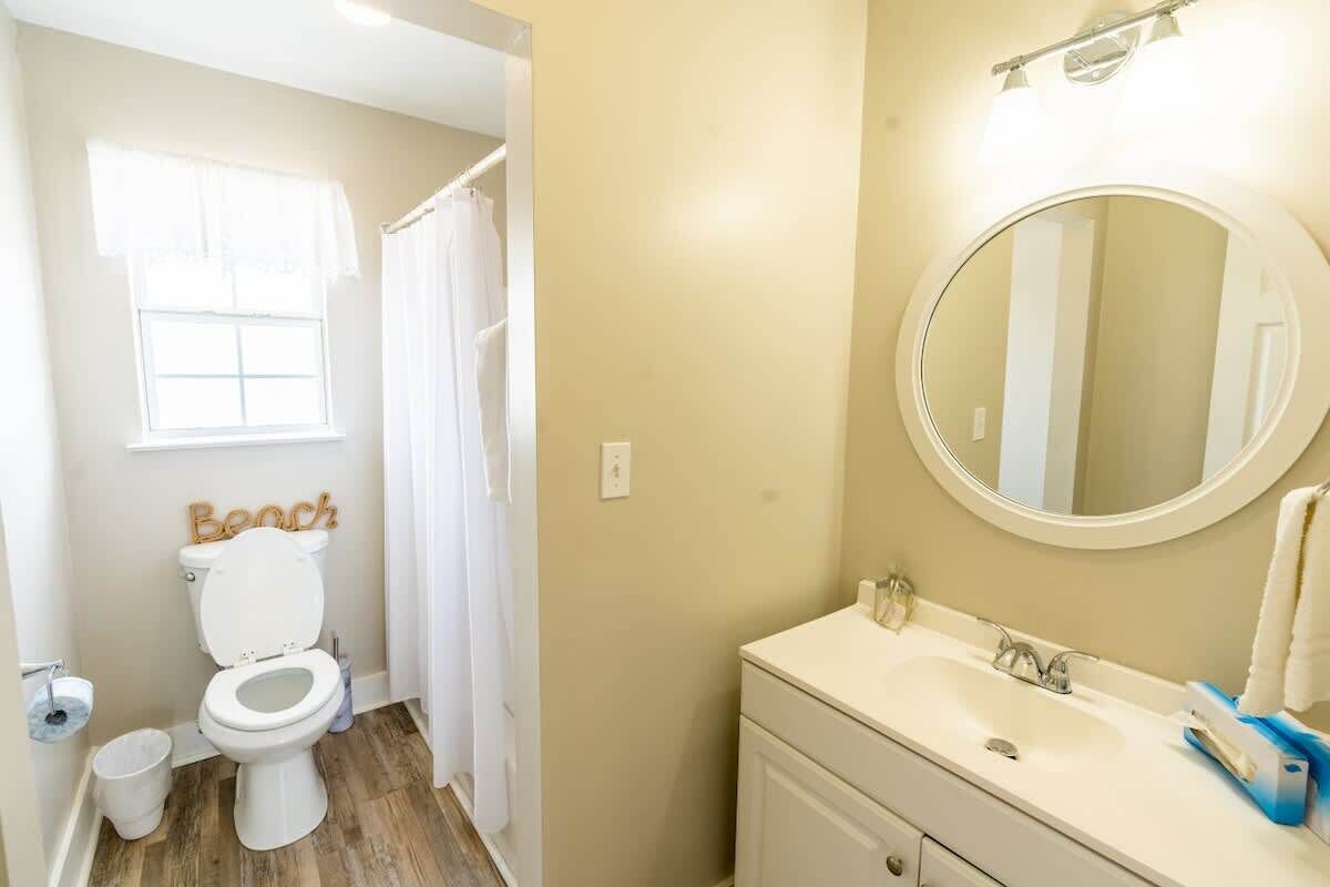 Full bathroom. Standing shower and tub. Vanity with mirror. Clean bathroom and toilet.