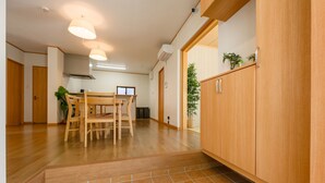 Una habitación amplia con una mesa de madera, sillas y un aparador.