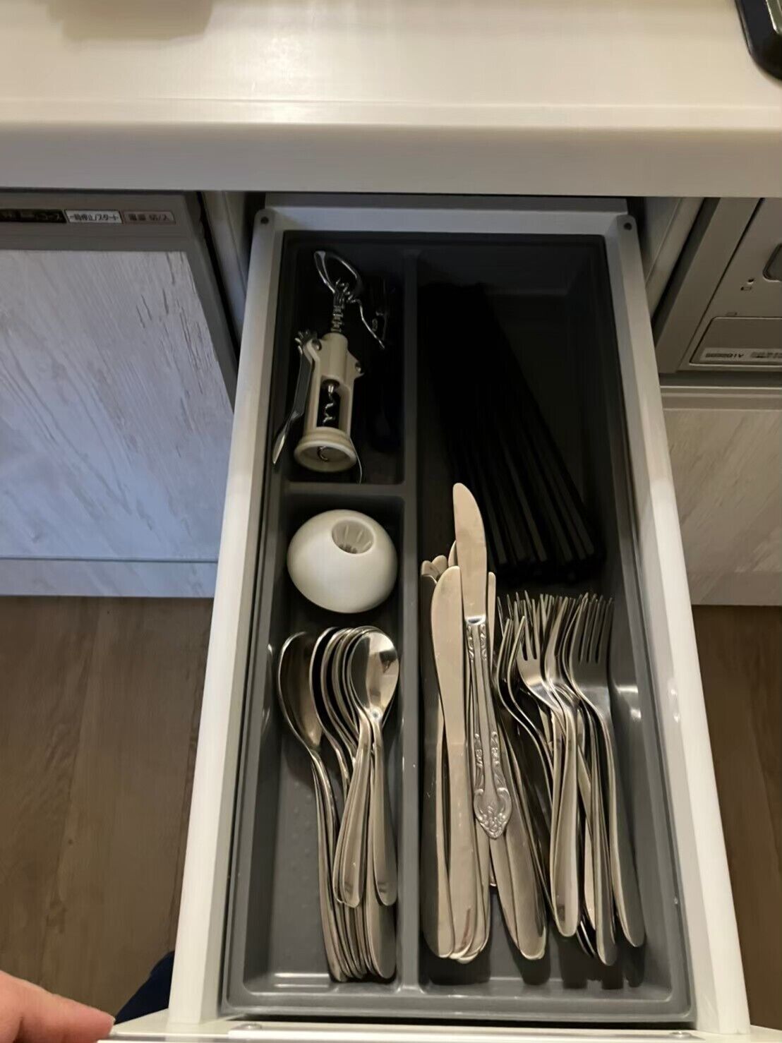 Un cajón con cubiertos ordenados, incluyendo tenedores, cuchillos y cucharas.