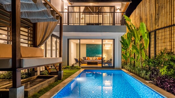 Et moderne hus med swimmingpool, balkon og have.