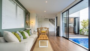 En moderne stue med sofa, sofabord og spiseområde.
