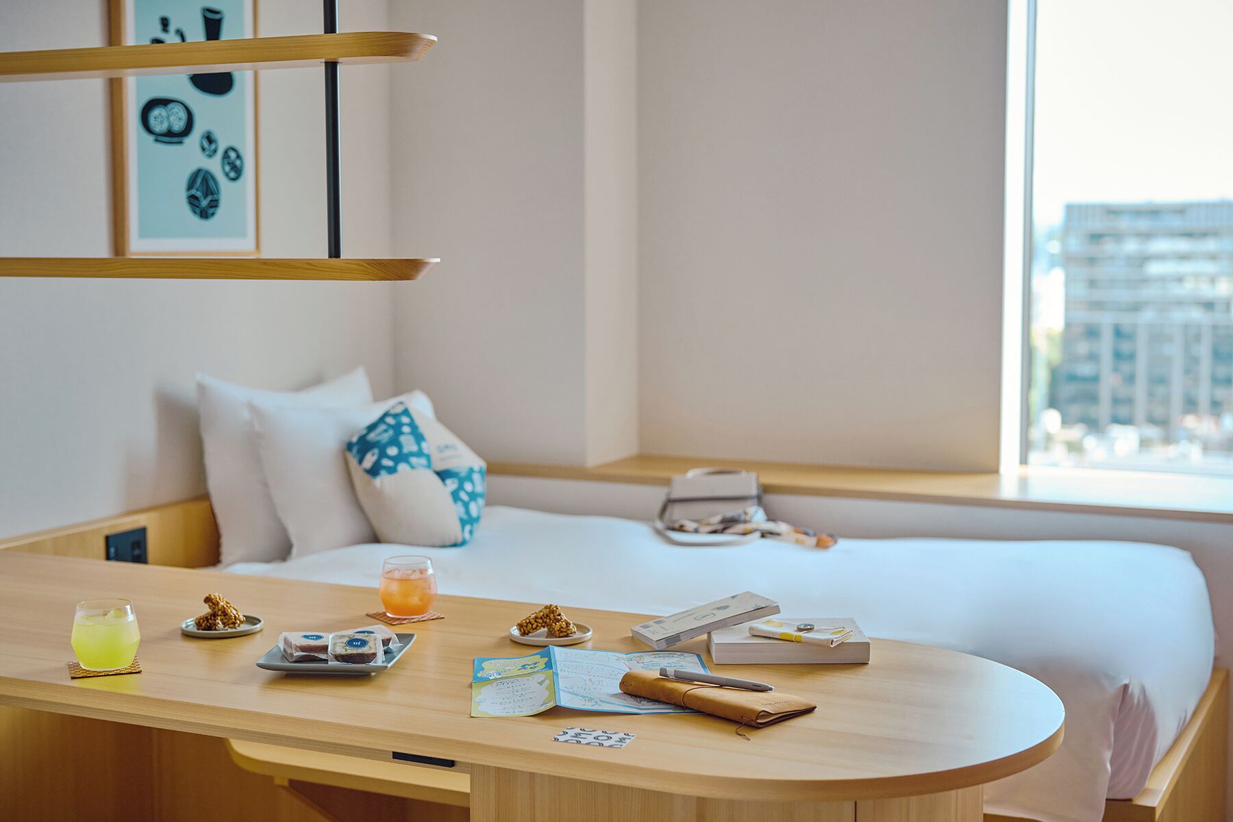 A neatly arranged hotel room with a bed, bedside table, and a window with a city view.