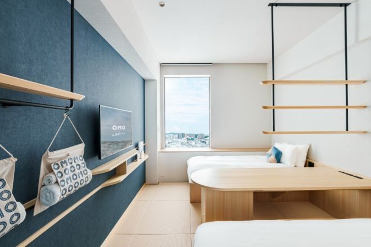 Una habitación de hotel moderna con cama, televisión y vista a la ciudad.