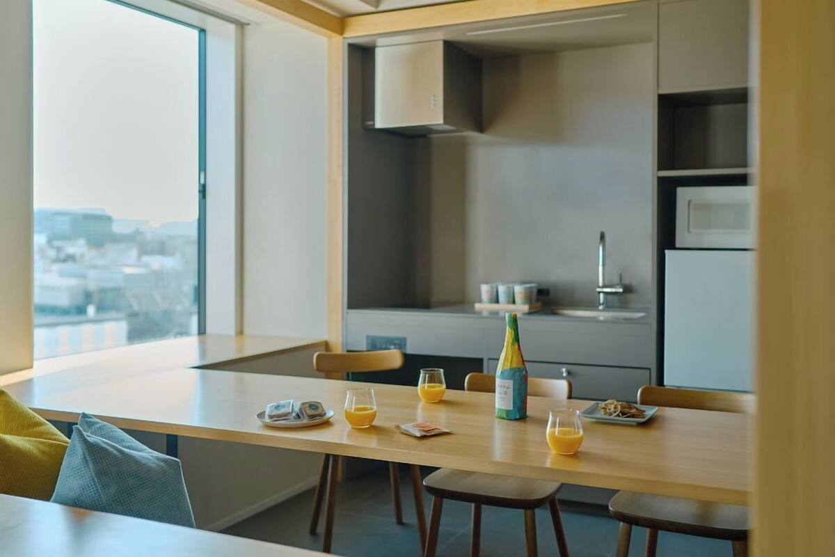 Una cocina moderna con comedor, una botella de champán y productos para el desayuno sobre la mesa.