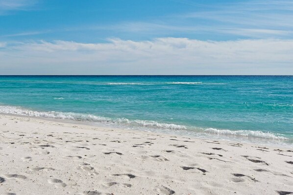 A beach with white sand and clear turquoise water.