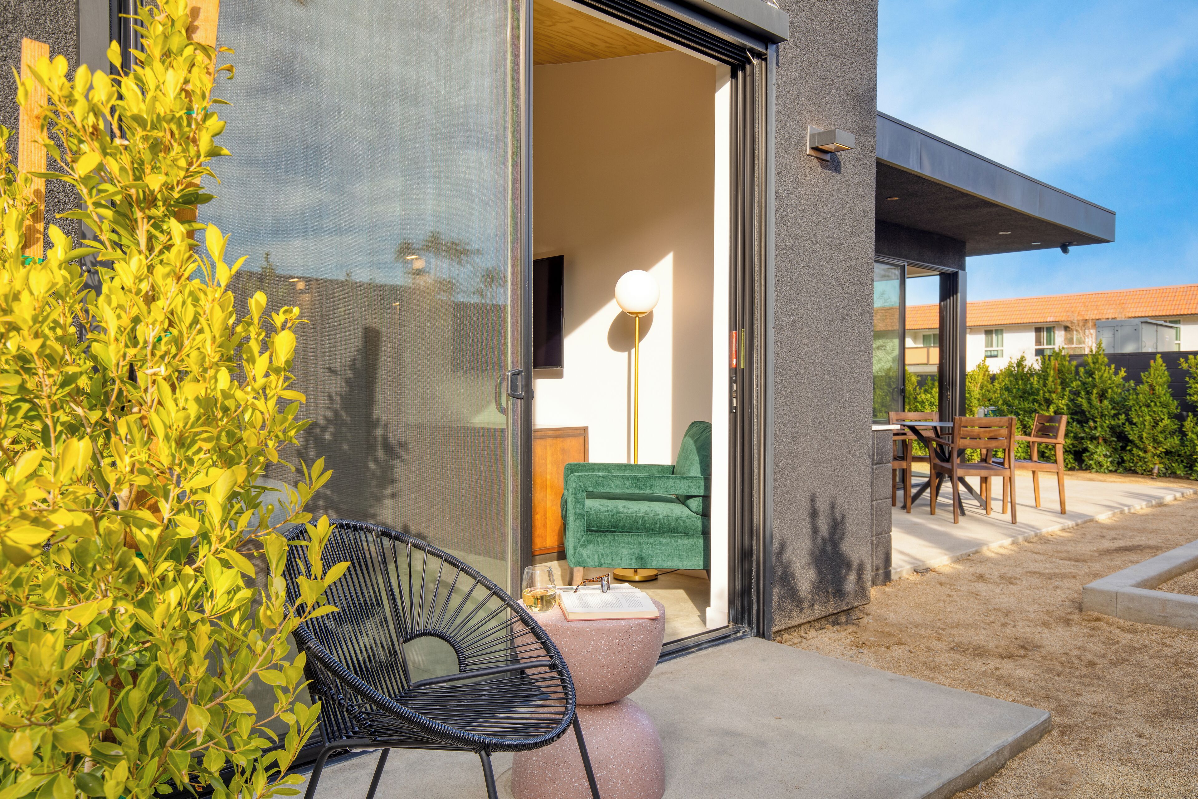 A modern building with a glass door leading to an outdoor seating area.