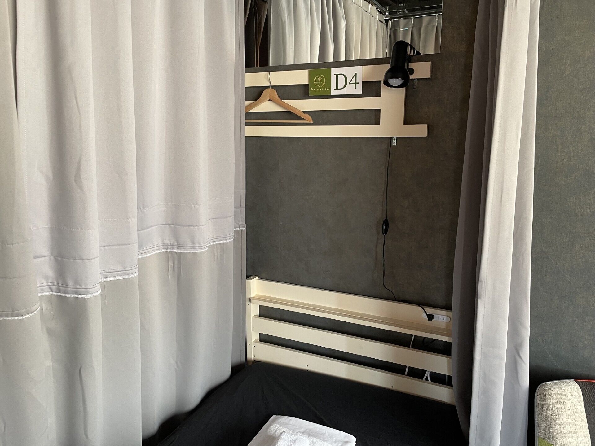 A bedroom with a bunk bed, a wooden hanger, a label with 'D4', and a power outlet.