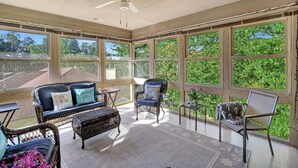 A sunroom with wicker furniture, large windows, and a ceiling fan. - Marina Village 338 In Keowee Key (Salem)