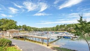 A marina with boats docked, a pedestrian bridge, and a small building on the left. - Marina Village 338 In Keowee Key (Salem)