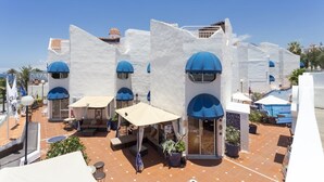 A white building with blue domes and outdoor seating areas. - Playa Flor Chill Out Bungalows (Arona)