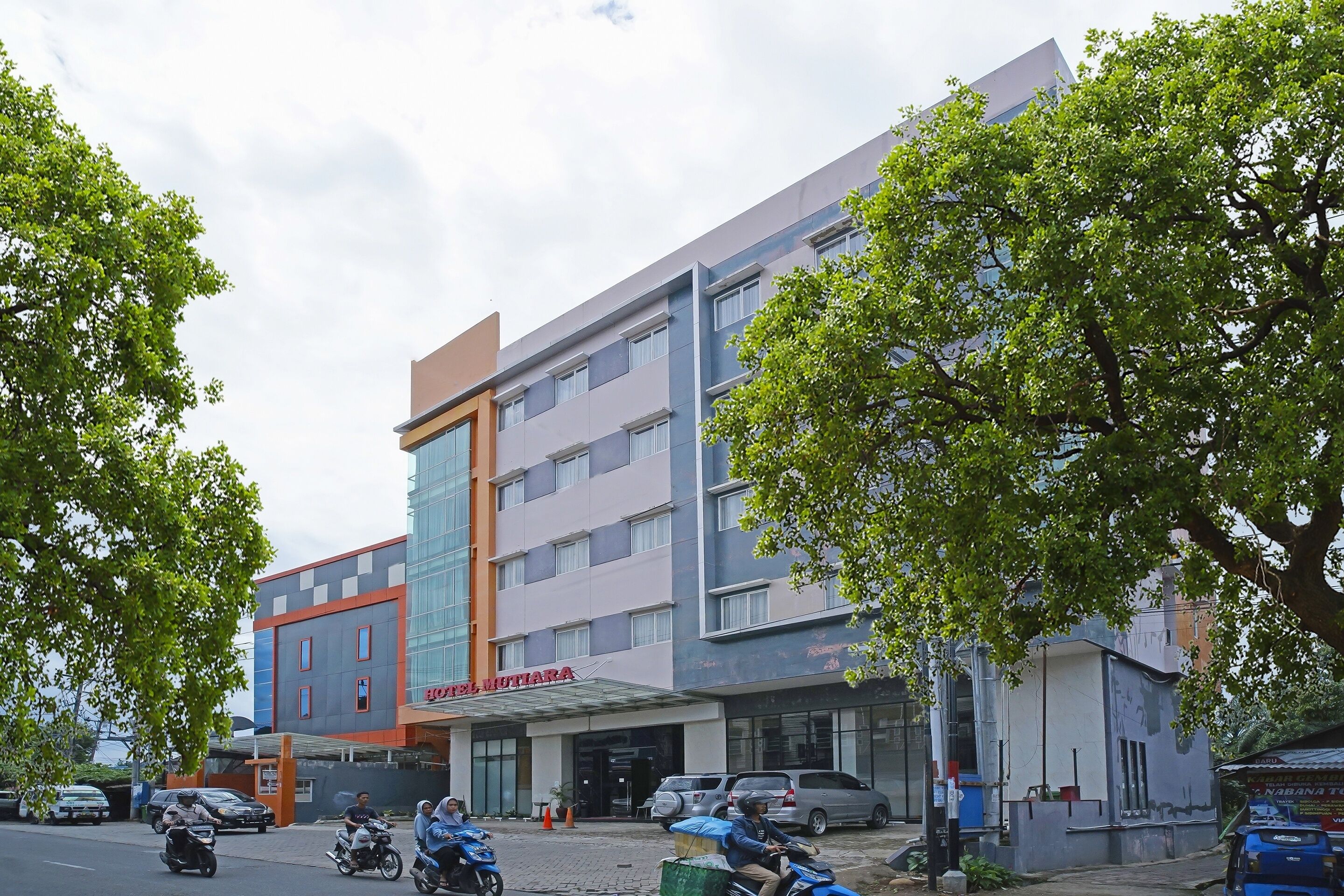 A hotel with a modern facade, multiple floors, and a prominent entrance.