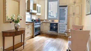 Une cuisine avec des meubles de rangement en bois, une cuisinière, un four et un lave-vaisselle.